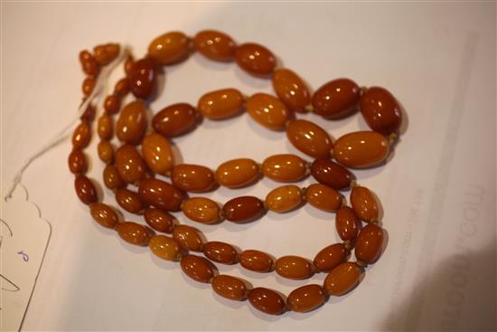 A single strand graduated oval amber bead necklace, 32in.